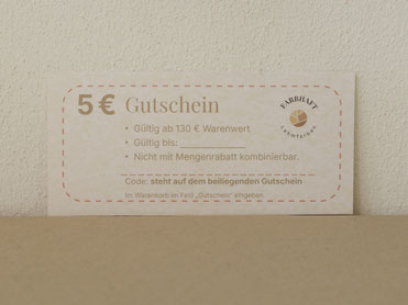 5-€-Gutschein für eine spätere Bestellung von Lehmfarbe vor heller Lehmwand.