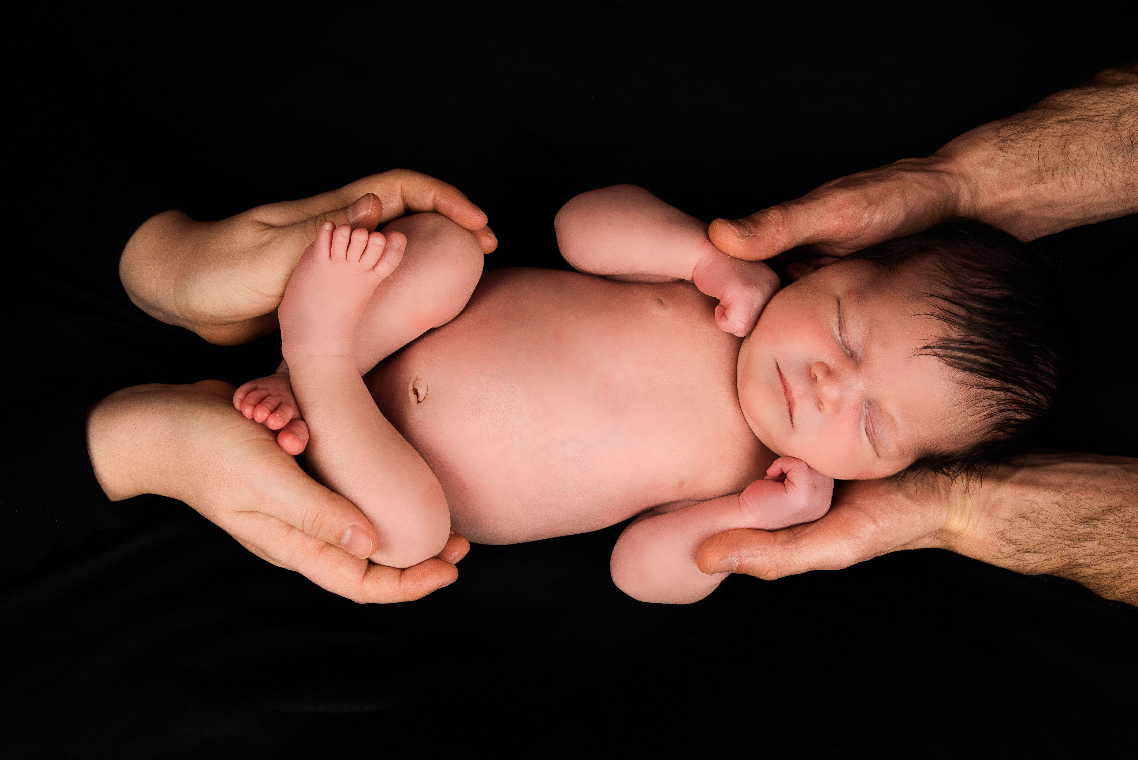 Baby wordt vastgehouden door beide ouders