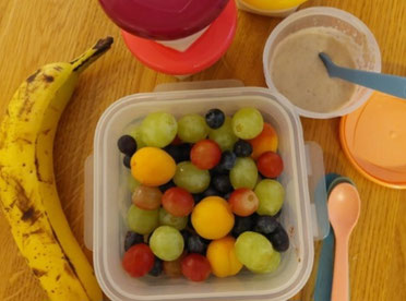Banane,Trauben und weitere Früchte sowie Joghurt in Frischhaltedosenr