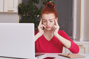 A focused student in front of a computer during an online Spanish lesson, symbolizing improved concentration and memory skills