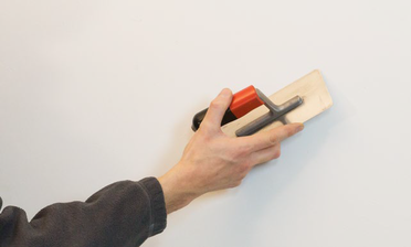 Stucco Fein Leichte Grate in der Kalkglätte werden abgeschabt.