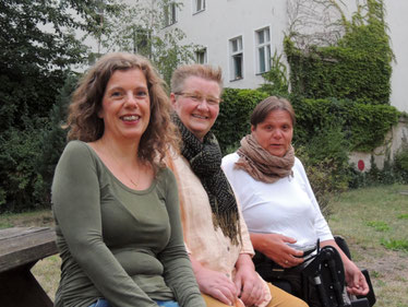 Auf dem Foto sind die Autorinnen Ilka Haederle, Doris Bewernitz und Andrea Lauer zu sehen. Sie sitzen in einer Reihe auf eier Bank, sehen in die Kamera und lächeln.