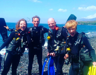 Estudiantes de Open Water felices con su instructor después de bucear en el pecio USAT Liberty en Tulamben