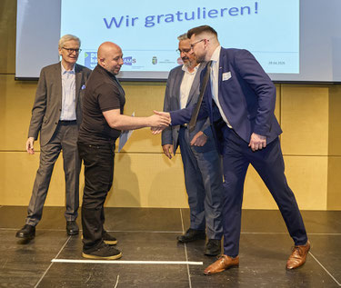 Handschlag bei der Übergabe – Gratulanten stehen bereit