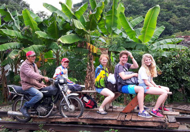 Vier Touristen mit Motorradführer auf der Brujita-Draisine in der kolumbianischen Kaffeezone