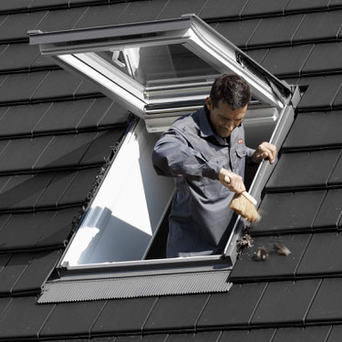 Laub und anderer Schmutz rund um ein Dachfenster sollten in regelmäßigen Abständen entfernt werden, damit das Regenwasser frei abfließen kann. Foto: Velux Deutschland GmbH