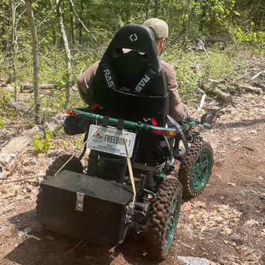 Wheelchair user, David Hudgik, is shown testing out the 'Freedom 1" TerrainHopper mobility vehicle on Lost Acre hiking trail.
