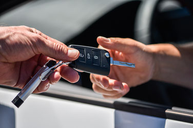 Übergabe eines Autoschlüssel an den Fahrer