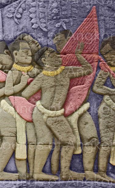 Harpist in standing position in a procession. Strings and pegs of indefinite number have been represented. Bayon temple.