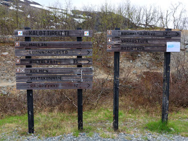 Sehenswürdigkeiten Kilpisjärvi - Dreiländereck: Mit schwarzer Farbe wurden Großbuchstaben in Holzbretter geschliffen, die den Weg zum Dreiländereck anzeigen.