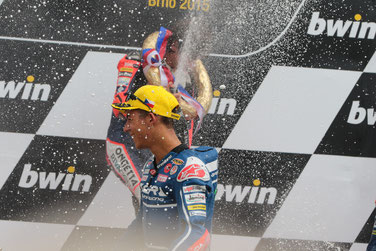 Hat gut Lachen: Enea Bastianini, zweiter in Brünn. Sieger Nicollo Antonelli lässt im Hintergrund den Champagner fliegen