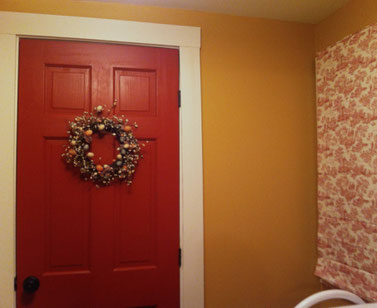 Deep and rich red door adds personality to the mudroom of this older home.