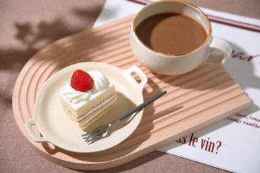 ショートケーキのお皿とコーヒーのマグカップがのったトレイ。