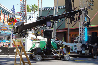 オーランドのユニバーサル・シティウォーク（Universal CityWalk）の様子。映画撮影用の大型クレーンカメラが設置され、背景にはスターバックスやレストランの看板が並ぶショッピング＆エンタメエリア (Universal CityWalk Orlando with camera crane setup, Starbucks and restaurants in the background).