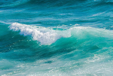 Eine gerade sich brechende Welle auf dem Meer