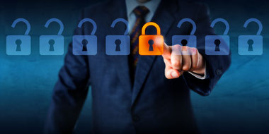 Row of 8 padlock images in foreground. 7 are greyed out and unlocked, one orange and locked.  business man in suit and tie touching finger to locked padlock.