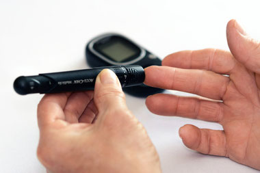 Hand mit Insulin-Pen misst Blutzucker bei Diabetes