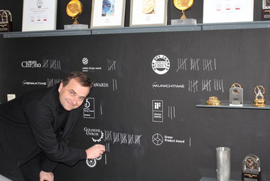 Nomos-Chef Uwe Ahrendt bei der Aktualisierung der hauseigenen Trophäenwand./Nomos CEO Uwe Ahrendt updating the inhouse trophy wall. Photo: Nomos Glashütte.