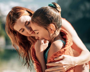 Familienurlaub am Wolfgangsee – Mutter und Kind am Wasser mit Bergkulisse im Salzkammergut