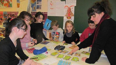 Coralie Berthou, ambassadrice du tri à la CCPL, avec un groupe d'enfants dans un jeu qui apprend le tri des déchets.