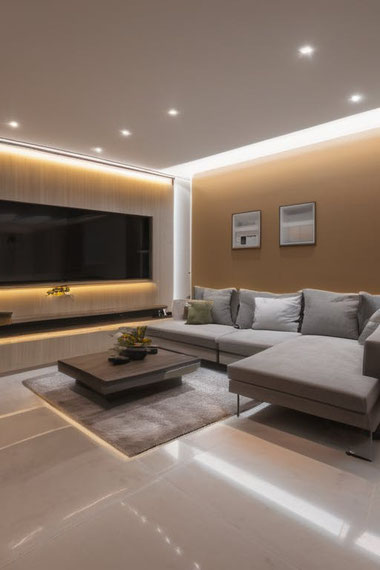 Indirekte Beleuchtung im Wohnzimmer sorgt rund um den Sessel für entspannte Wohlfühlzonen und hebt mit sanftem Licht Design und Gemütlichkeit hervor.