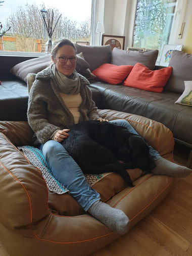 Nina Hoffmann mit Hündin Emily im Hundekorb kuschelnd
