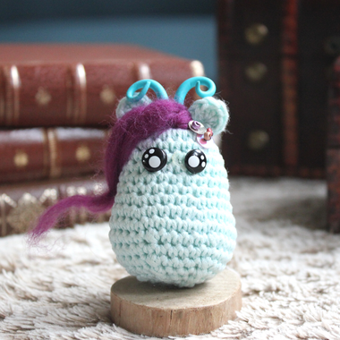 personnage totem fantastique ondine, bleu glace avec des cornes et des paillettes, fait à la main au crochet