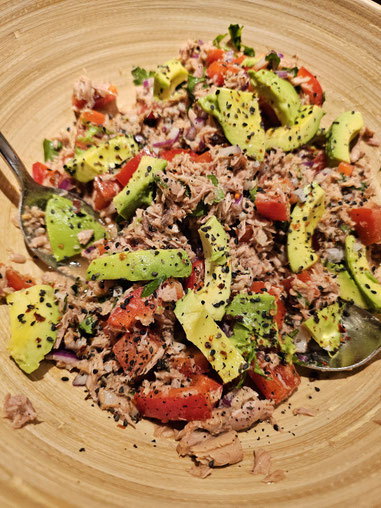 Thunfisch mit Avocado, Paprika, Tomaten und frischer Petersilie in einer großen Holzschüssel