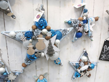 Blau-weiß Sterne als Weihnachts Dekoration an weißer Holzwand.