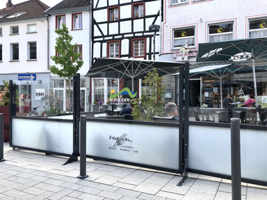 Windschutz-Anlage für Café-Terrasse in historischer Altstadt, konform zur städtischen Gestaltungssatzung, mit dezentem Branding