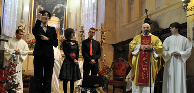 Don Paolo che annuncia l'esibizione del Coro Mani di Luce