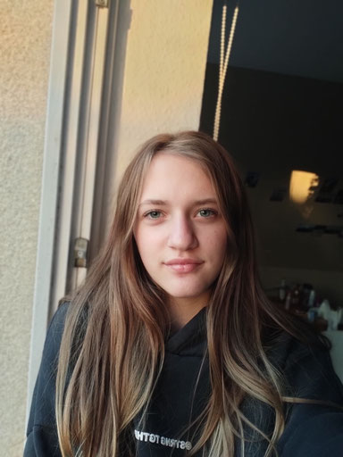 Porträt von Friederike Ohnesorge. Jugendliches Gesicht, blaue Auge, braunes, langes Haar.