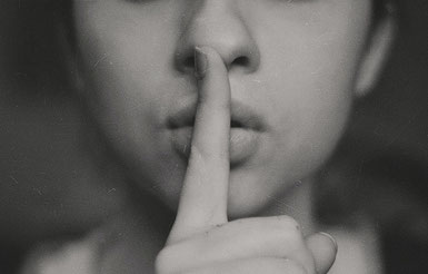 une femme avec l'index devant la bouche