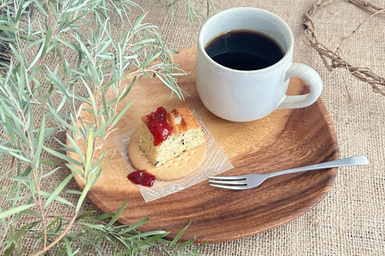 パウンドケーキとコーヒーの入ったマグカップがのった木製のトレイ。