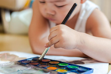 Kleines Kind beim Malen mit Wasserfarben