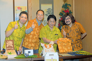 石垣市特産の開襟シャツを身に着け、商品を前に、FB登録を祝う樋渡武雄市市長(右から3人目)ら=ゆんたく屋、大川