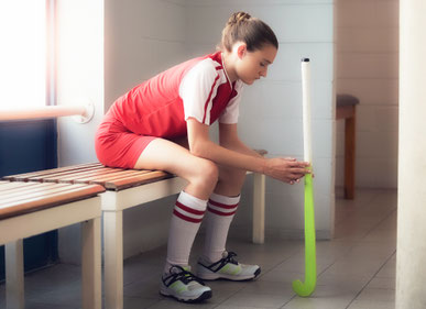 Unihockeyspielerin sitzt auf der Bank und konzentriert sich