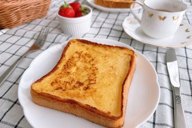 フレンチトーストのお皿とナイフとフォーク。イチゴが盛り付けられた器とカップ&ソーサ。お休みの日の朝食。