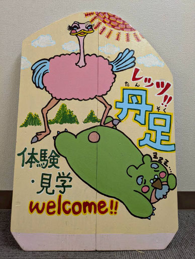 真ん中で二つ折りできて持ち運びやすく作製された木製看板 踏み合うダチョリーヌ&くまん イラスト可愛い