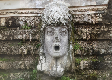 Relief sculpture on a wall of a head with its mouth wide open