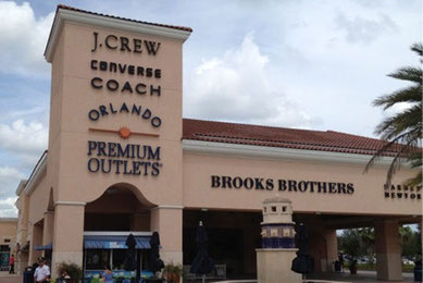 オーランド・ヴァインランド・プレミアム・アウトレットの入口風景。J.CREWやCOACH、BROOKS BROTHERSなど有名ブランドが集まるショッピングモールで、観光客に人気の買い物スポット (Orlando Vineland Premium Outlets with J.CREW, COACH, Brooks Brothers stores, famous shopping destination for tourists).
