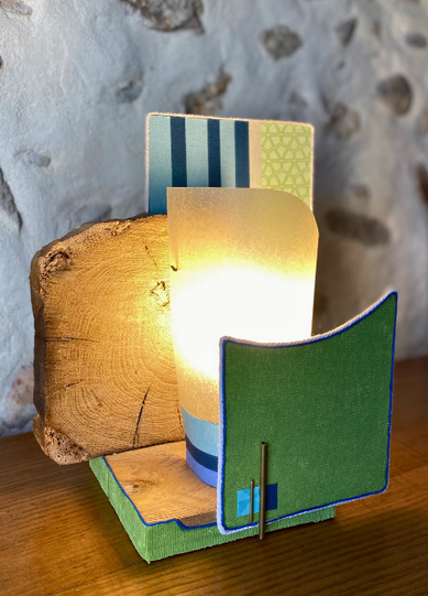 Lampe à poser authentique et artisanale faite main, une idée cadeau unique en Haute-Savoie. Une pièce de créateur en bois et tissu effet velours vert et jeu de laiton sur l'avant. 