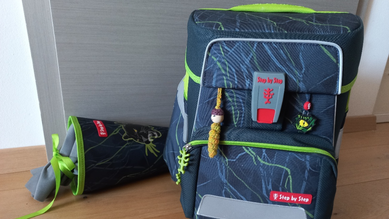 Schultüte und Schultasche stehen auf dem Boden nebeneinander
