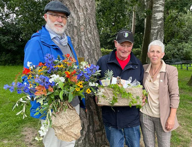 Gerhard Boll und Dunja Pucks übergeben Blumen und Präsent an den Jubilar.