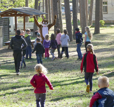 Der Osterhase war gekommen und winkte die Kinder zu sich.