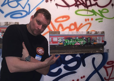 Oliver Nebel vor Graffitiwand