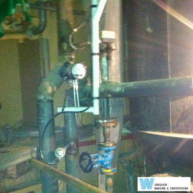 An engine room of a ship with both a PT100 temperature sensor and a ATH thermostat installed in the piping.