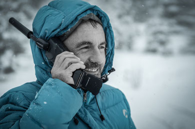 A man using a satalight phone in the mounatins