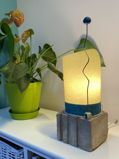 Idée cadeau déco originale en Haute Savoie, cette lampe artisanale et design en béton  et  papier de soie vert et tige de laiton. Luminaire de création originale et déco proche d'Annecy .