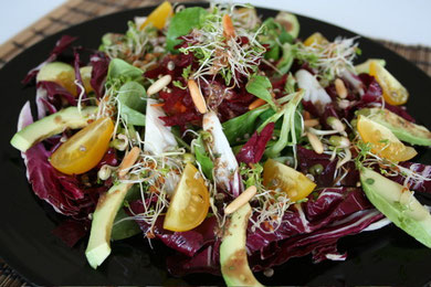 Field salad and radicchio with avocado, sprouts and yellow cherry tomatoes